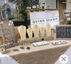 there are many different items on the table for sale at this outdoor market, including mannequins and necklaces