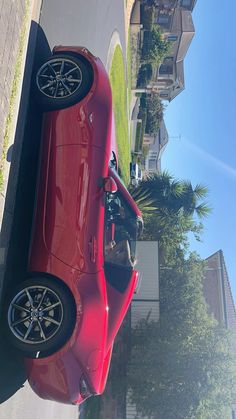 a red car is parked on the side of the road