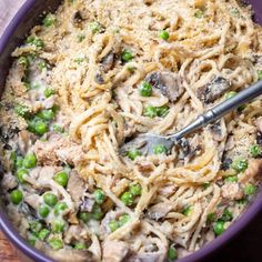 a purple bowl filled with pasta and peas