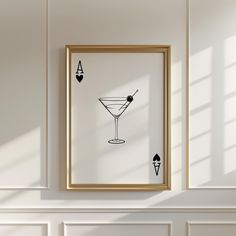 a framed art piece hanging on the wall next to a white fireplace with an image of a martini