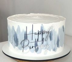 a birthday cake with blue paint splattered on it and the words happy birthday written on top