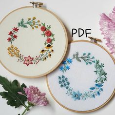 two embroidery hoops with flowers and leaves on them