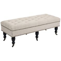 an upholstered bench with black legs and studded trimmings on it