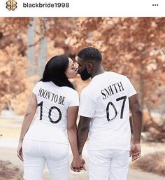 a man and woman in matching shirts kissing