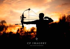 the silhouette of a man holding a bow and arrow in front of an orange sky