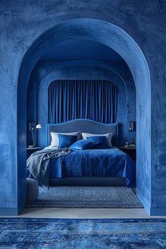 a bedroom with blue walls and an arch leading to the bed in the room is lit by two lamps on either side of the bed