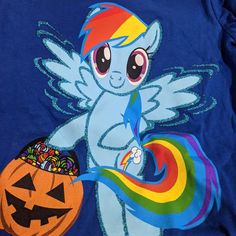 a blue shirt with an image of a rainbow pony holding a candy bowl and a pumpkin