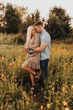 a man and woman hugging in a field of flowers