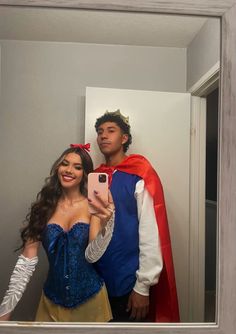 a man and woman in costumes taking a selfie