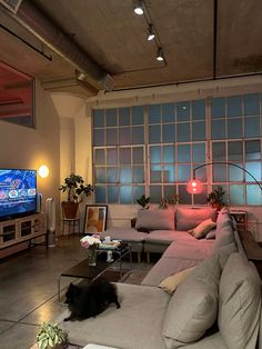 a living room filled with lots of furniture and a flat screen tv mounted on the wall