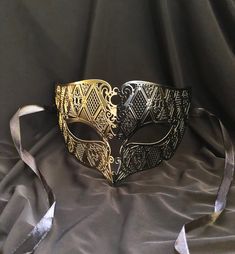 This men's luxury Masquerade mask is painted in a two-tone gold and black color. Then mask has a unique design and is made out of a lightweight metal. Mask has some flex and has a smooth comfortable fit. Stand out at your next Masquerade ball or Venetian mask party with this unique mask!  Color: gold and black. Black And Gold Masquerade Mask, Masquerade Mask Black, Couples Masquerade Masks, Gold Masquerade Mask, Masquerade Prom, Luxury Mask, Mens Masquerade Mask, Masquerade Wedding, Venetian Masquerade Masks