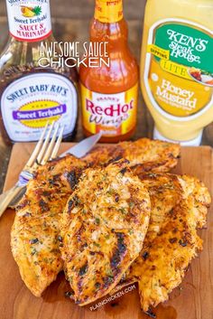 grilled chicken on a cutting board with ketchup and mustard in the background