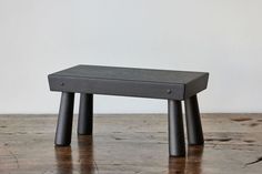 a small wooden stool sitting on top of a hard wood floor