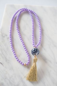 A classic gold tassel and beautiful ginger jar styled porcelain bead is accented by light purple resin beads. Tassel measures 3.5", necklace measures 32" long. Handmade in Charleston, South Carolina. Colorful Headbands, Purple Resin, Hand Painted Beads, Strung Beads, Tassel Bracelet, Tassel Jewelry, Ginger Jar, Charleston South Carolina, Resin Beads