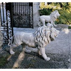 a statue of a lion standing in front of a gate