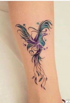 a woman's foot with a tattoo on the side of her leg that has a bird and flowers on it