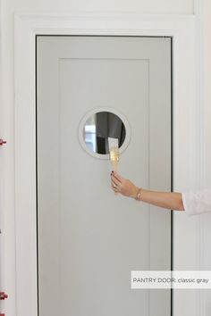 a woman holding a wine glass in front of a door