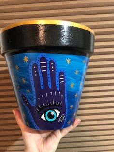 a hand painted pot with an eye on it