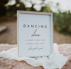 a photo frame sitting on top of a rock next to a white cloth draped over it