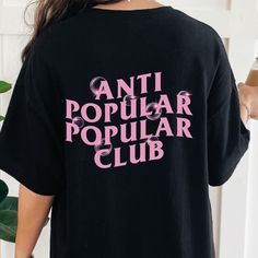 the back of a woman's black shirt that says anti popular club on it