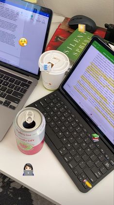 an open laptop computer sitting on top of a desk next to a cup of coffee