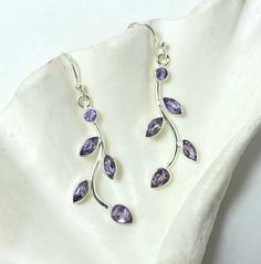 "These magnificent and delicate amethyst drop earrings feature AAA grade natural amethyst pieces that are precisely set in 925 sterling silver setting. The natural amethyst pieces are daintily arranged in a leafy silver setting giving a delicate look. These amethyst earrings are made from hypoallergenic 925 sterling silver. So, If you like to stand out from the crowd, this unique design of amethyst drop earrings is a must-have!! *Note that photos are enlarged to show the details clearly. Please verify the dimensions in the description.  Earring Description:- Metal Type:- 925 Sterling Silver Gemstone Type:- Natural Amethyst Weight:- 5.05 gm (approx.) (weight in grams of both earrings) Stone treatment :- 100% Natural Earring Length:- 5 cm Earring Breadth:- 0.7 cm Earring Shape : Round and Pe Nickel-free Amethyst Lavender Earrings, Lavender Amethyst Teardrop Earrings, Nickel-free Lavender Amethyst Earrings, Lavender Amethyst Gemstone Earrings, Lavender Amethyst Dangle Earrings, Lavender Amethyst Drop Earrings, Purple Amethyst Long Drop Earrings, Lavender Amethyst Earrings With Ear Wire, Lavender Amethyst Earrings