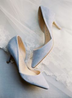 the bride's wedding shoes are sitting on top of her dress and lace veil