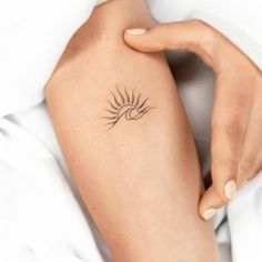 a woman with a sun tattoo on her arm