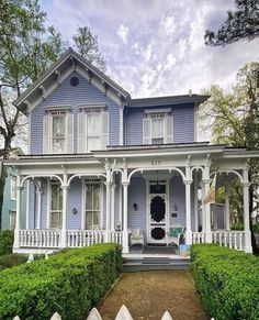 a blue house with white trim on the front porch