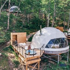 a woman sitting on a deck in front of a yurt with a hot tub