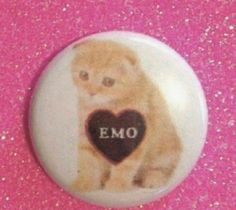 a small button with an emo heart on it's center and the word emo written in black