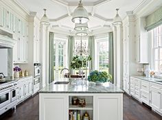 a large kitchen with white cabinets and marble counter tops, along with a center island