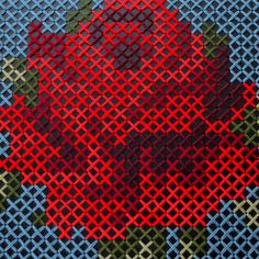 a red flower is shown on a blue and green background with an intricate design in the center