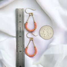 Make a statement with Lane - Gold & Coral! These 14k Gold filled teardrop hoop earrings featuring Peach coral seed beads will guarantee you some serious style points. Perfect for a fun summer night out! Approximately 1.75” long Made with 14k Gold Filled wire Glass Miyuki Seed Beads Polished to a high shine Handmade in Montana Sent in a ribboned gift box with polishing cloth Beaded Teardrop Earrings For Summer, Gold Teardrop Earrings For Summer, Summer Beaded Teardrop Earrings, Summer Teardrop Beaded Earrings, Spring Teardrop Jewelry, Nickel Free Teardrop Earrings For Summer, Wire Wrapped Teardrop Hoop Earrings, Summer Teardrop Earrings With Ear Wire, Trendy Teardrop Jewelry For Spring