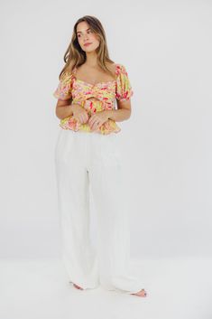 Introducing the Arlet Top in Yellow Multi Floral, a versatile piece that offers premium style with bright pops of color, just in time for spring. This piece pairs beautifully with linen trousers or cut-off denim, and is sure to steal the show no matter where you wear it. FIT: Runs true to size - fitted in the bodice, with cropped silhouette. MATERIAL: Self: 100% Polyester; Lining: 95% Polyester, 5% Elastane. GARMENT DETAILS: Cropped floral top with puffed sleeves and a bandeau-style bodice; feat Spring Floral Print Linen Tops, Spring Linen Floral Print Tops, Relaxed Fit Cargo Pants For Spring, Spring Vacation Pants, Multicolor Linen Tops For Spring, Spring Linen Top For Brunch, Casual Linen Floral Print Bottoms, Trendy Rayon Bottoms For Spring, Cropped Bottoms For Spring Day Out