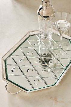 a mirrored tray with wine glasses on it