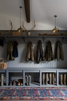 the coat rack is full of coats and boots, along with other items on display