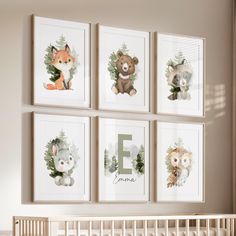 a baby's room with four framed pictures on the wall and a crib