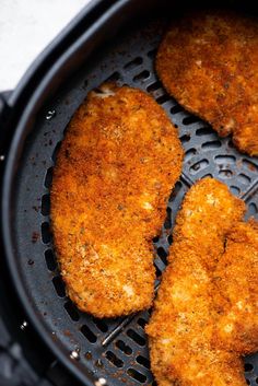 four pieces of chicken cooking in an air fryer