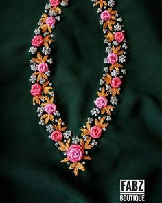 an elaborate necklace with pink flowers and silver beads on a green silk background, the words fabz boutique written below it