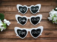 four heart shaped magnets with wedding date written on them and flowers in the background