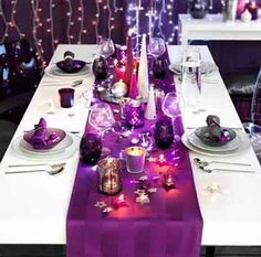 the table is set with purple candles and plates