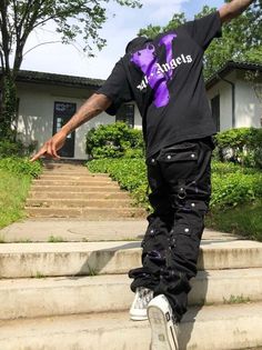 a man riding a skateboard down the side of a flight of stairs with his hand in the air