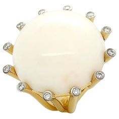 A lustrous white coral embodies the warmth of 18k yellow gold and diamonds for this La Luna ring. Secured by narrow cylinders of 18k yellow gold, the ring features a round 25mm carving of white coral with a single brilliant cut diamond on each tip. A multi-split shank forms as the cylinders join. The total weight is 0.29 carats of brilliant cut diamonds and 54.14 carats of white coral. Measurements for the ring are 1.25 inches (width) by 1.25 inches (length) by 0.5 inches (depth). White Coral, 18k Yellow Gold Ring, Split Shank, Domed Ring, Yellow Gold Ring, The Ring, Brilliant Cut Diamond, Yellow Gold Rings, Gold Ring