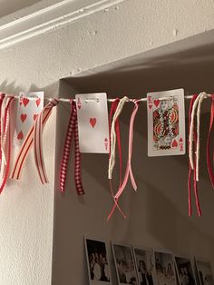 some cards are hanging on a line with red and white ribbons attached to the string