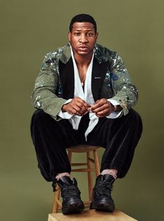 a man sitting on top of a wooden stool