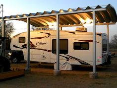 an rv is parked under a metal awning