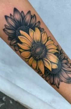 a sunflower tattoo on the left forearm and right arm, with an arrow pointing to it