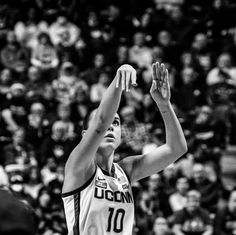 a women who is reaching up for a basketball