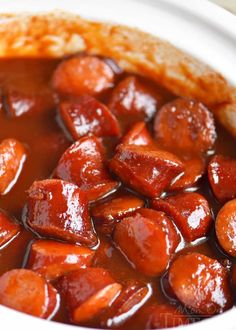 a close up of food in a bowl with sauce on the top and meat inside